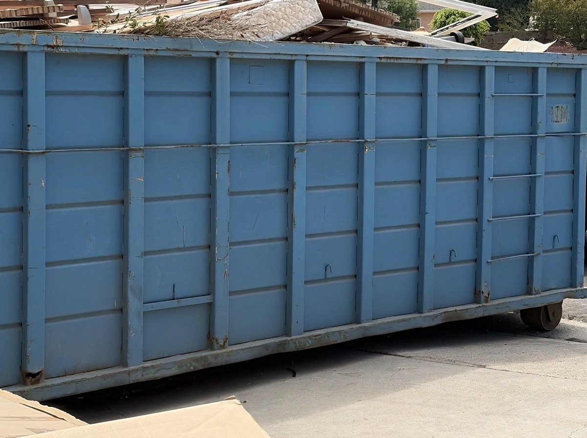 Ecowaste roll-off dumpster loaded with debris on a San Fernando Valley job site
